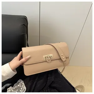 Detail view of the elegant beige square bag with a golden D-ring metal buckle and chain strap