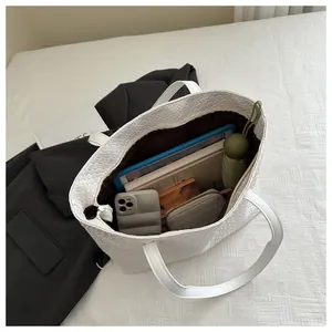 Internal view of white woven tote bag showing spacious capacity with an iPad and items