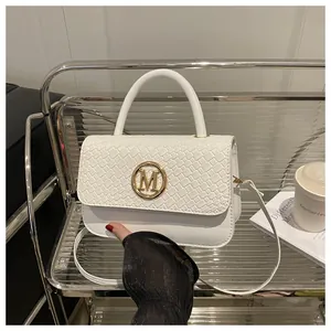 Détail du sac à main blanc tissé avec boucle métallique M dorée et poignée supérieure