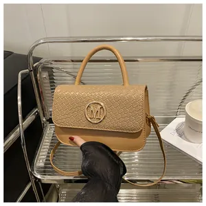 Détail du sac camel à texture tressée avec logo M doré et bandoulière amovible chic