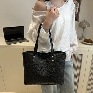 Fashionable black woven leather tote bag with silver rivets, perfect for daily commuting