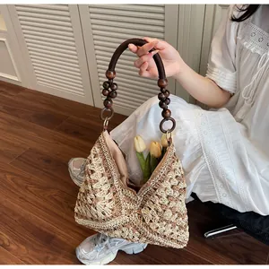 Detail of woven tote bag featuring contrast textures and dark wooden bead handle accents