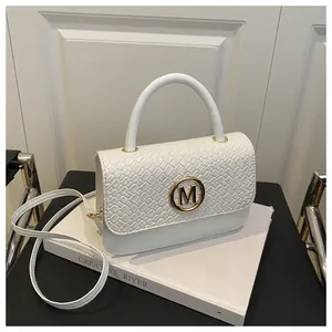 Détail du sac à main blanc tissé avec boucle dorée M et rabat élégant à motif de serpent