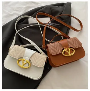 Close-up of stylish contrast-stitched square handbags with gold oval metal clasps
