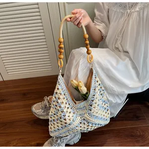 Detailed close-up of woven crochet tote bag with wooden bead handle and blue plaid pattern