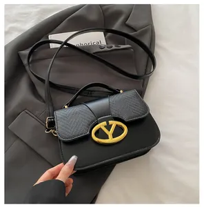 Detail of black crossbody bag with woven texture flap and golden Y-shaped metal buckle