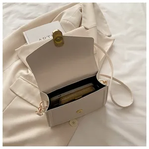 Vue détaillée de l'intérieur du sac beige avec un smartphone et un petit portefeuille