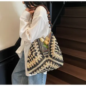 Detail of hand-woven tote bag with geometric pattern and unique wooden bead handle