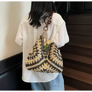 Detail of hand-woven tote bag featuring contrast geometric patterns and large wooden beads