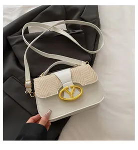 Close-up of white leather handbag with beige straw weave texture and gold buckle