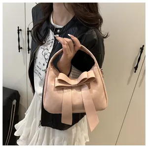 Détail du sac à main rose avec grand nœud élégant et attaches pour bandoulière chaîne