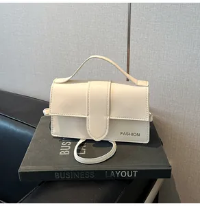 Detail view of off-white minimalist shoulder bag with top handle and fashion text logo