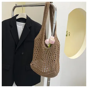 Detail of hand-woven dark brown mesh tote bag with wide shoulder strap and floral decor