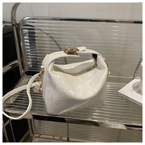 Detail of white snakeskin texture handbag with gold hardware and secure zipper closure