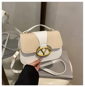 Detail of elegant white leather handbag with woven texture flap and gold metal buckle