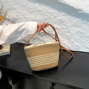 Straw weave bucket bag with striped pattern and adjustable leather strap for summer
