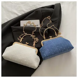 Dettaglio borse a tracolla vintage in bianco e blu denim con finiture metalliche dorate