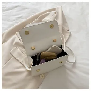 Intérieur pratique d'un sac bandoulière blanc avec espace pour téléphone et portefeuille
