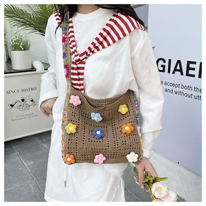 Close-up of bohemian knit shoulder bag featuring colorful 3D crochet floral patterns