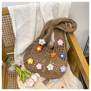 Detail of handmade crochet tote bag with colorful 3D knitted flowers on a vintage chair
