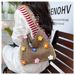 Detail of bohemian knit tote bag with vibrant 3D crochet flowers and patterned strap