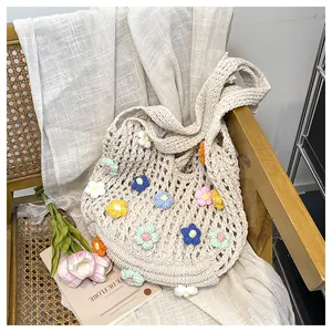 Detail of handmade crochet tote bag with colorful 3D knitted flowers on a vintage chair