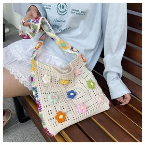 Detail of crochet crossbody bag with 3D colorful flowers and floral strap