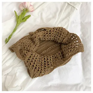 Close-up of brown crochet tote bag showing intricate knit texture and hollow-out weave pattern