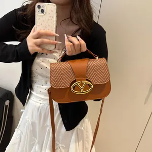 Brown leather and woven crossbody bag with gold metal buckle shown on a model