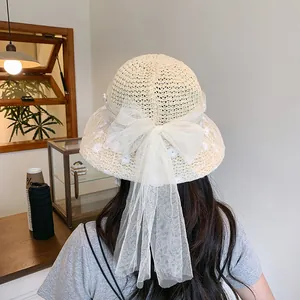 Fashionable beige straw hat with large white lace bow and embroidery for summer