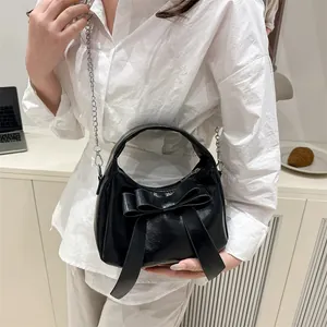 Sac demi-lune noir avec grand nœud décoratif et bandoulière en chaîne argentée