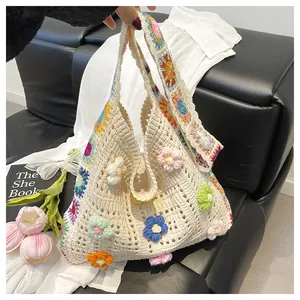 Detail of handmade crochet handbag with colorful 3D flowers and granny square strap