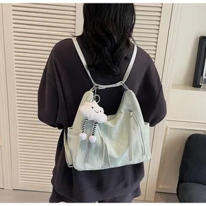 Détail du sac à dos vert menthe en nylon plissé avec une breloque nuage blanc doux