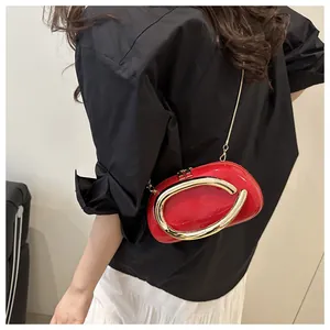 Détail de la pochette demi-cercle en cuir verni rouge avec boucle en anneau doré massif