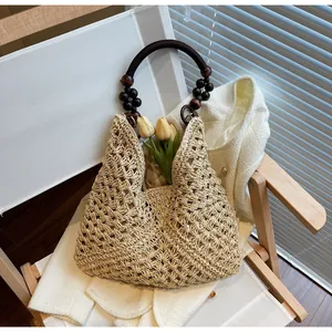 Detail of woven straw tote bag featuring vintage wooden bead handles and hollow-out texture
