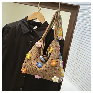 Detail of hand-knit crochet shoulder bag with colorful 3D flowers and bohemian strap
