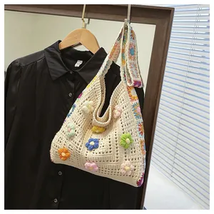 Detail of hand-crocheted tote bag featuring colorful 3D knit flowers and hollow texture
