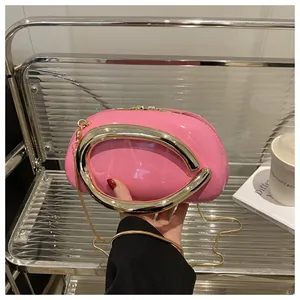 Détail du sac rond en cuir verni rose avec poignée en anneau métallique doré