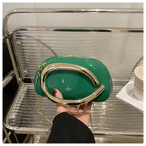 Détail du sac à main en cuir verni vert avec poignée et chaîne en métal doré