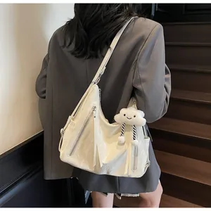 Dettaglio della borsa tote color crema con cerniera argento e portachiavi a forma di nuvola