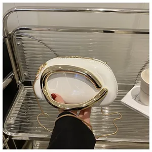 Détail du sac en cuir verni blanc avec poignée en U dorée et bandoulière chaîne