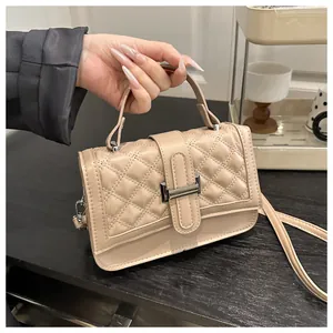 Détail du sac beige en similicuir matelassé avec fermoir argenté et poignée de main
