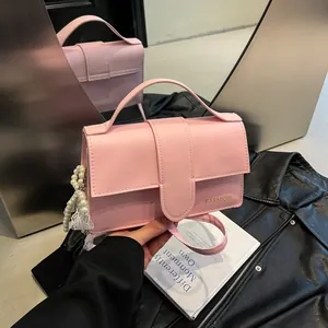Pink PU leather shoulder bag with pearl chain and FASHION lettering in a mirror view