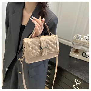 Détail du sac à main matelassé à carreaux porté par un mannequin pour un look chic