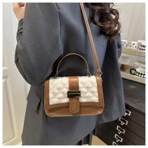 Photo de style de vie d'une femme portant un petit sac carré bicolore marron et blanc surpiqué