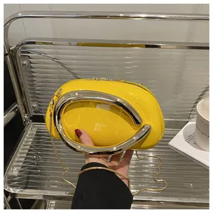 Détail du sac en cuir verni jaune vif avec poignée anneau argenté et bandoulière chaîne