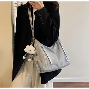 Dettaglio borsa hobo grigio argento con trama trapuntata, zip e ciondolo a nuvola