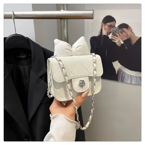 White pebbled leather mini crossbody bag featuring a 3D bow and floral turn-lock buckle