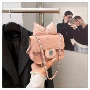 Close-up of quilted pink mini bag with large bow and silver camellia metal lock