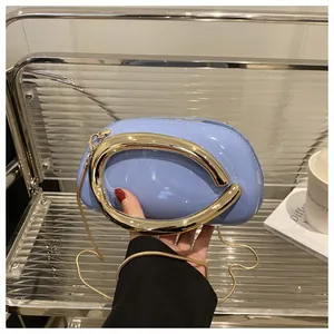 Détail du sac à main en cuir verni bleu clair avec poignée anneau dorée et chaîne
